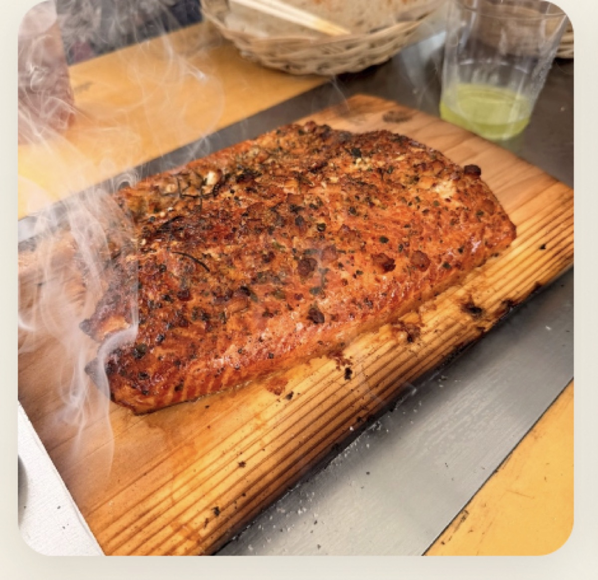 杉板の上で煙をまとうサーモン