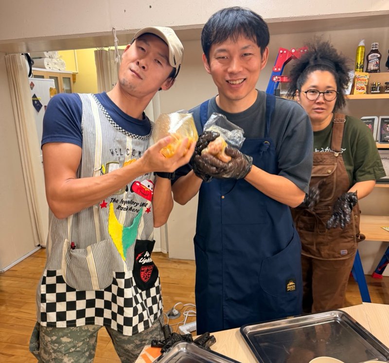 スパイスをもみ込んだチキンを手に