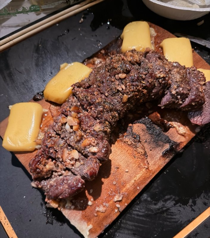 グリルにのせた板の上の鹿肉とチーズ